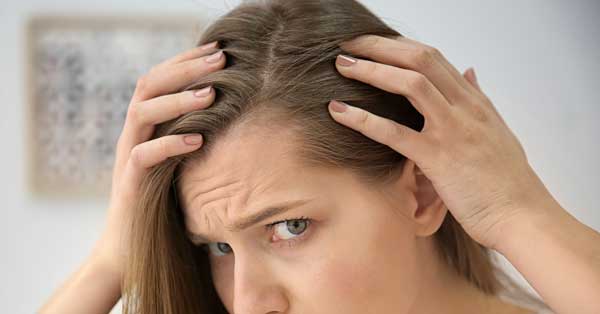 woman checking scalp for hair loss